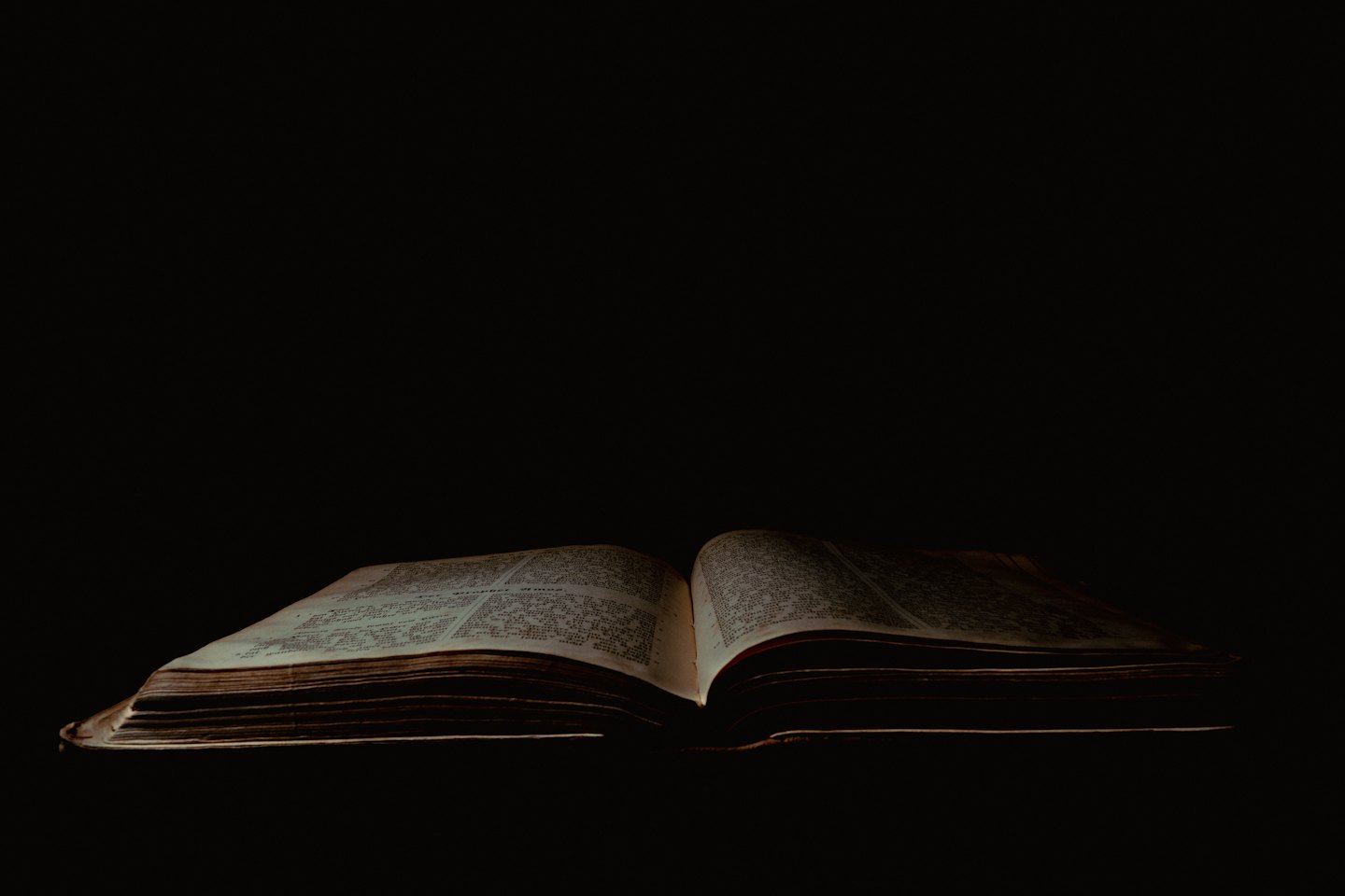 Ein aufgeschlagenes altes Buch mit leuchtenden, verwitterten Seiten.